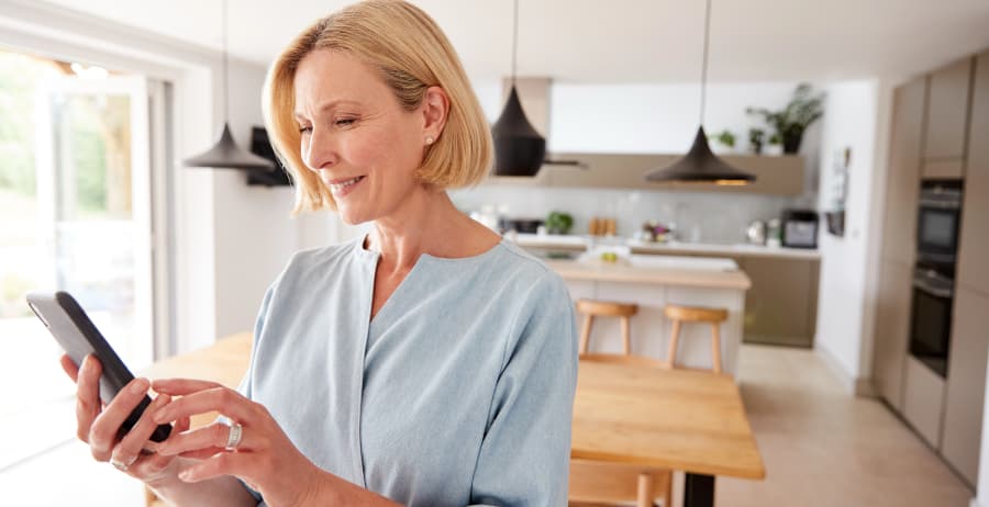 Woman holding a smartphone in a modern home